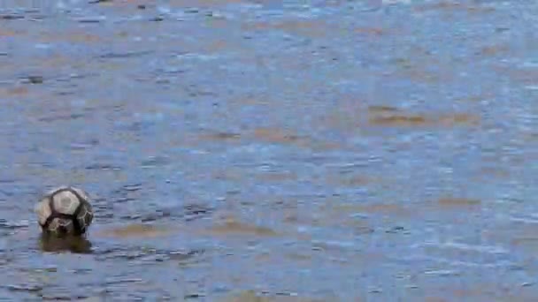 Le ballon de foot nage sur la rivière .