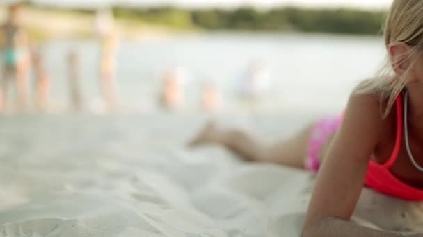 Маленькая Красивая Девочка Лежит Белом Песке Пляжа Большого Озера — стоковое видео