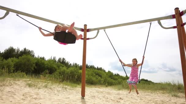 Two little beautiful girls on swing Baltic Sea in Jurmala, Latvia. — Stock Video