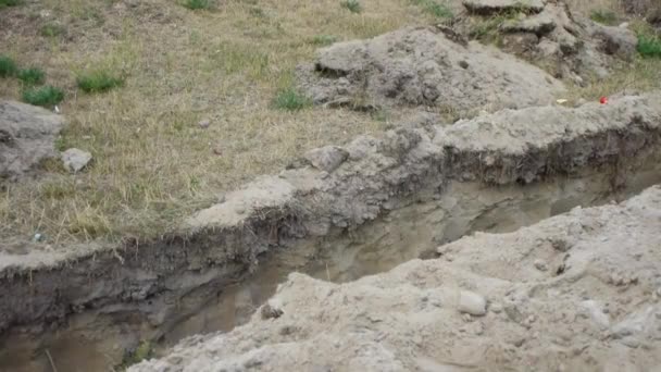 Little girl jumps over an earthen ditch, dug for laying pipes. — Stock Footage Little girl jumps over an earthen ditch, dug for laying pipes. Royalty Free Stock Video