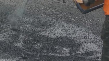 İnşaat işçisi olan çakıl yol ve asfalt özel ekipman yardımı ile delik tamir.