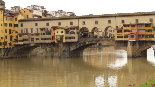 Ponte Vecchio (gamla bron) är medeltida sten stängd-spandrel segmentell bro över floden Arno, i Florens, Italien, noteras för att fortfarande ha byggt längs den, som var en gång vanligt. — Stockvideo