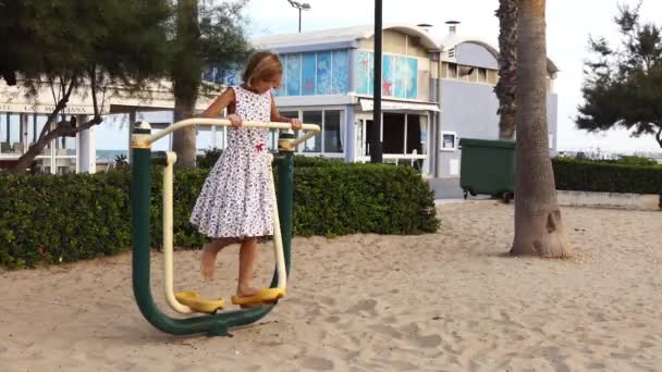 Kleines Mädchen Verlobt Sich Auf Metall Sportsimulator Strandnähe Mit Meer — Stockvideo