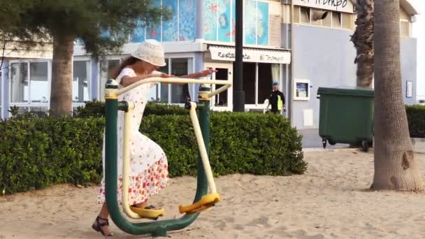 Liten Flicka Engagerad Metall Sport Simulator Nära Stranden Med Havet — Stockvideo