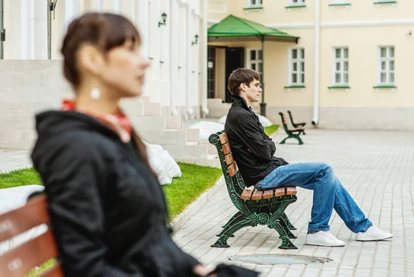 Mladá Žena Mladý Muž Sedí Různých Lavicích Kolem Krásné Budovy — Stock fotografie