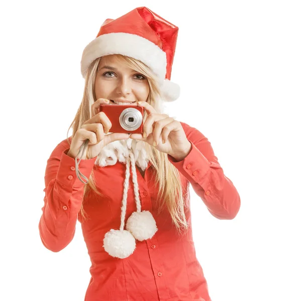 美丽的微笑的年轻妇女在圣诞老人帽子和红色衬衫与照相机 查出在白色背景 — 图库照片