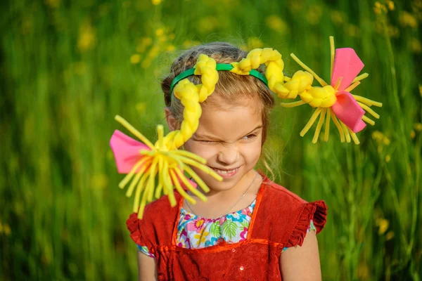 Kleines Mädchen Rotem Kleid Und Künstlichen Zöpfen Vor Sommergrünem Hintergrund — Stockfoto