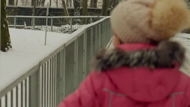 Mooie Meisje Winter Pak Wandelingen Buurt Van Metalen Hek — Stockvideo