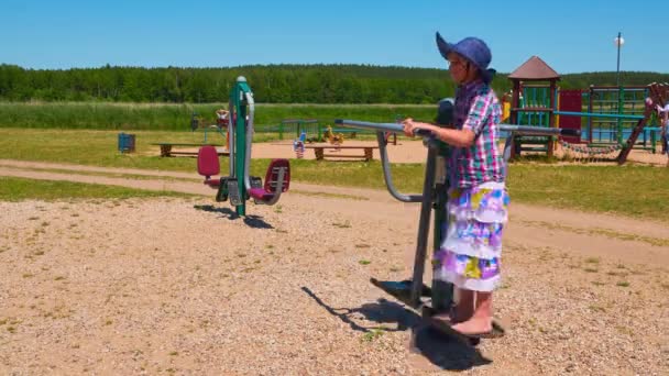 Kleines Mädchen Metallsportsimulator Nahe Strand Mit See Verlobt — Stockvideo