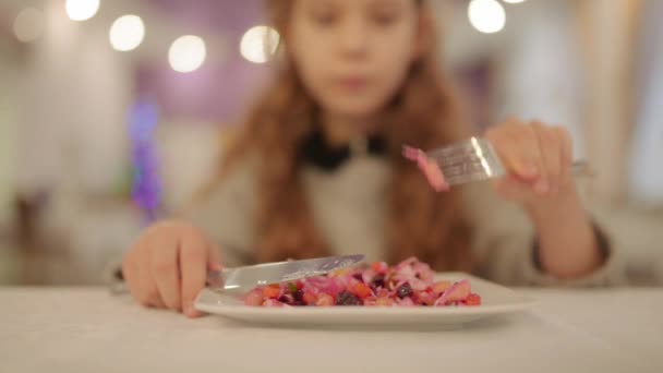 美しい十代の少女フォークとナイフを使って食べる大カフェのサラダ ビネグレット — ストック動画