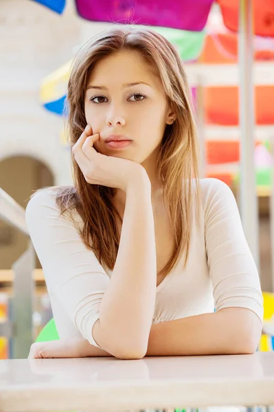 Fiatal gyönyörű nő, hosszú haj, asztalnál ülő — Stock Fotó