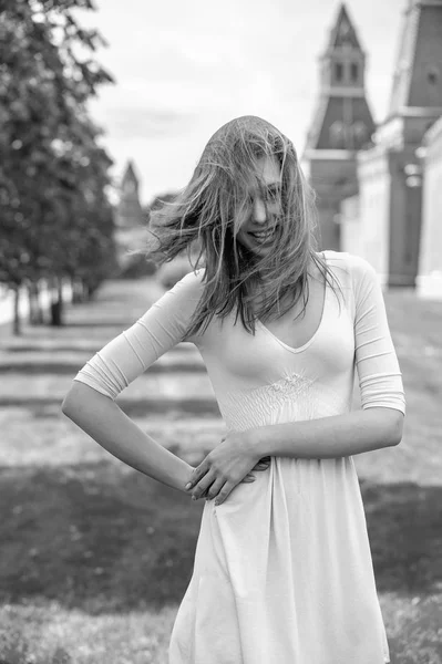 Uma bela jovem mulher em um vestido branco com voar no vento o cabelo contra o pano de fundo do Kremlin de Moscou na Rússia — Fotografia de Stock