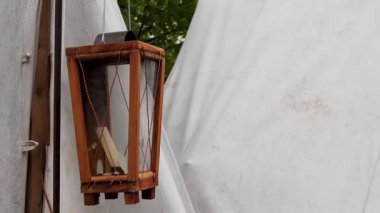 çadırın yakınındaki bir tarla kampında rüzgarda bir mum sallar ile ahşap bir fener
