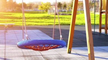 mavi şehir parkının arka planına karşı yuvarlak salıncak