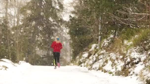 Giovane Atleta Bionda Corre Attraverso Giardino Inverno Durante Una Nevicata — Video Stock