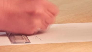 öğrenci bir cetvel ve kalem ile bir kağıt parçası üzerinde koordinat düzlemi çizer