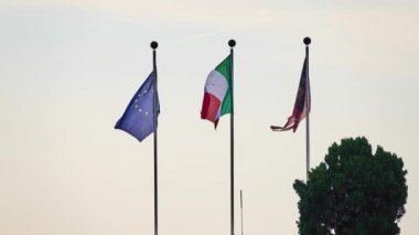 3 bayrak: İtalya, Avrupa Birliği ve Veneto eyaletleri rüzgarda bayrak direkleri çırpınan