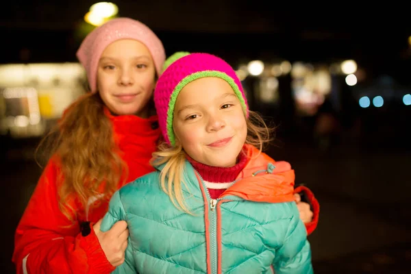 Duas Irmãs Pequenas Alegres Bonitas Jaquetas Contra Noite Cidade — Fotografia de Stock