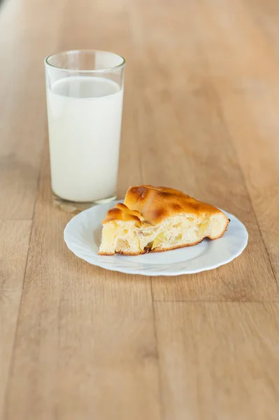 Ένα Κομμάτι Κέικ Και Ένα Ποτήρι Γάλα Ένα Ξύλινο Τραπέζι — Φωτογραφία Αρχείου