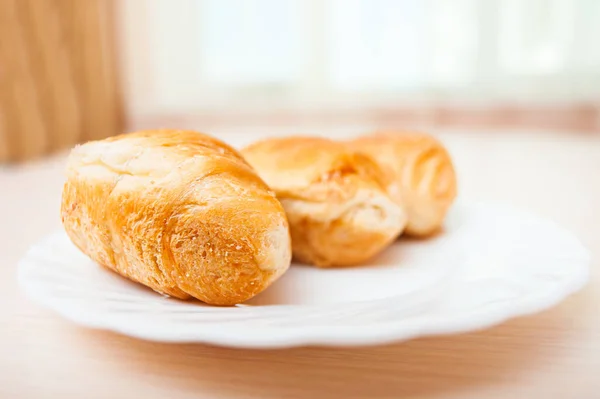 Frische Croissants Auf Einem Weißen Teller Auf Dem Tisch — Stockfoto
