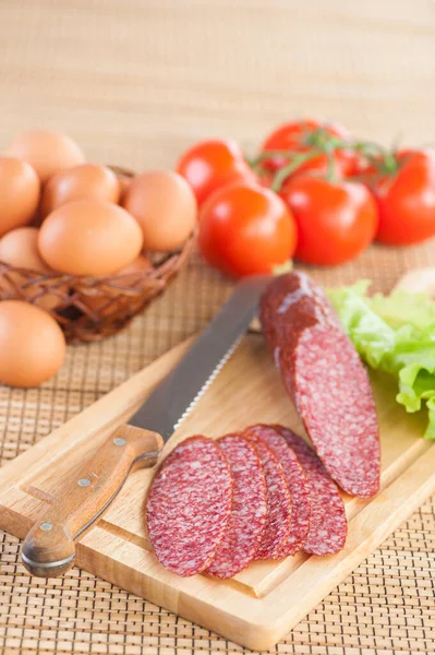 Tasty Sausage Knife Lying Cutting Board Wicker Basket Eggs Red — Stock Photo, Image