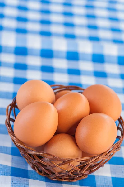 Rieten Mand Met Eieren Een Geruit Blauw Tafelkleed — Stockfoto