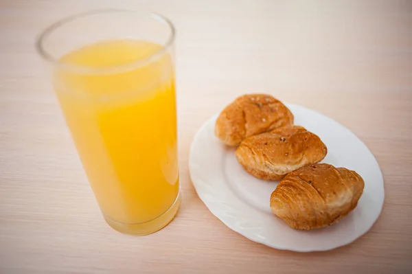Verse Croissants Een Wit Bord Een Glas Sinaasappelsap Tafel — Stockfoto