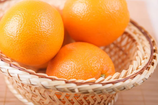 Τρία Μεγάλα Πορτοκάλια Ένα Ψάθινο Καλάθι Από Μπαμπού Τραπεζομάντιλο — Φωτογραφία Αρχείου