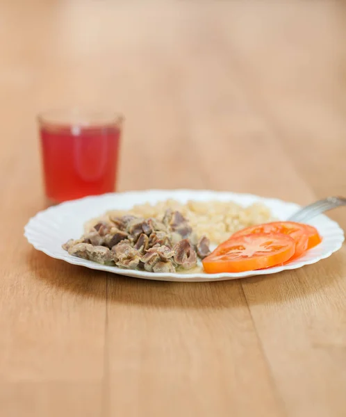 有意大利面 西红柿和果汁的鸡排放在木制桌子上的白盘上 — 图库照片