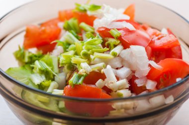 Soğanlı salata ve cam kasede kırmızı domates..