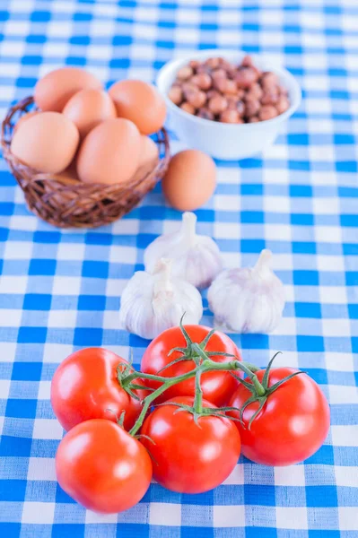 Dalda Kırmızı Domates Yumurtalı Sepet Sarımsak Fındıklı Kareli Mavi Masa — Stok fotoğraf