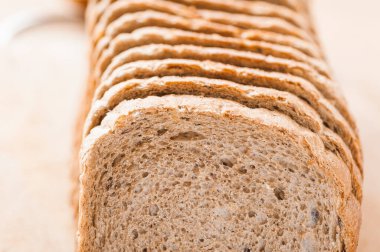 Kesme tahtasının üzerinde dilimlenmiş bir somun ekmek..