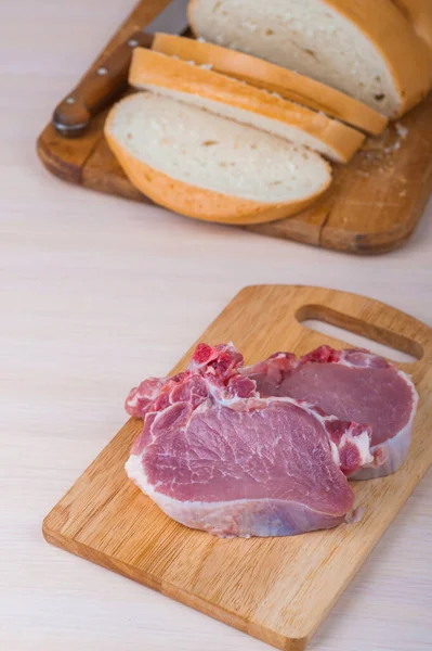 Carne Porco Deitada Uma Tábua Corte Madeira Rolo Pão Trigo — Fotografia de Stock