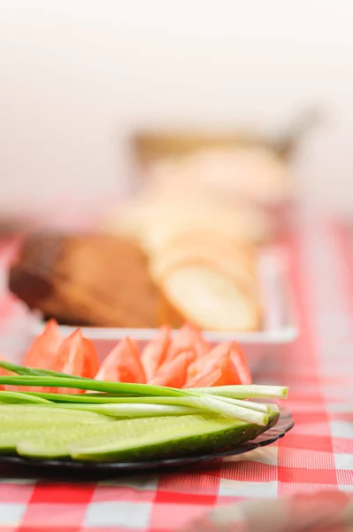 切碎的黄瓜和西红柿 红桌布上的黑白相间的面包 — 图库照片