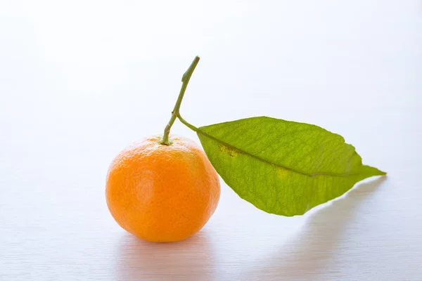 Una Mandarina Madura Con Hoja Verde Sobre Una Mesa — Foto de Stock