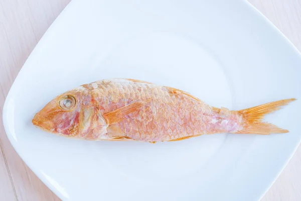 Κόκκινο Ψάρι Ξαπλωμένο Λευκό Πιάτο — Φωτογραφία Αρχείου