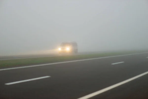 Rechtstreekse Asfaltweg Ochtendmist Passeren Van Auto Met Gloeiende Lichten — Stockfoto