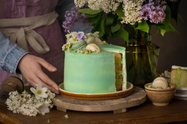Güzel kadın eller güzel yeşil pasta ve çiçekler, gıda fotoğraf barış ile