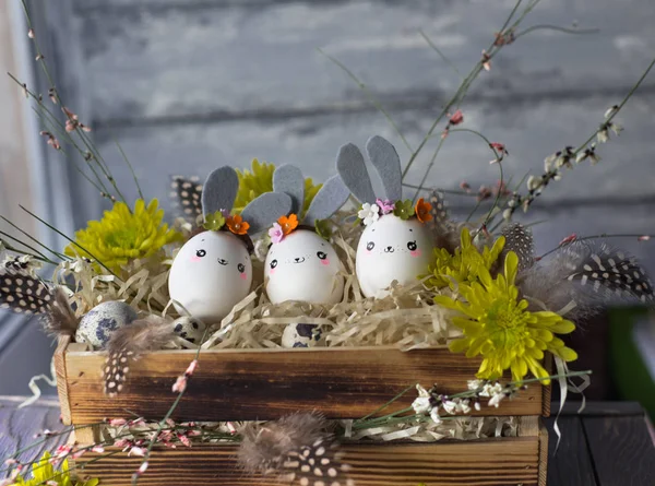 Paskalya arka plan, ev yapımı yumurta kabuğu bunnies ve sarı chrysant