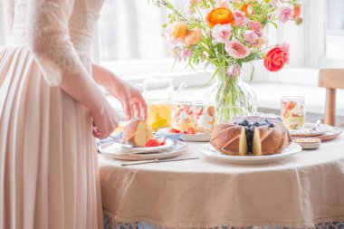 Çay saati, Kadın elleri elinde çaydanlık, çiçek ve kek