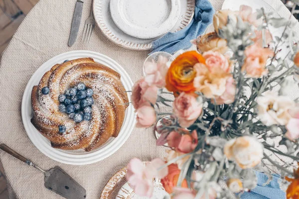 Table de pâtisserie arrangement de fleurs sur le dessus — Photo