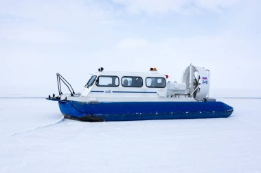 LAKE BAIKAL, RUSSIA - MARCH 05, 2017: Boat on an air cushion Khivus on the ice of the frozen Lake Baikal, Siberia, Russia clipart