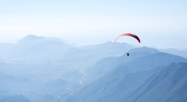 Türkiye 'nin Antalya ilinin Türk Rivierası' ndaki bir sahil beldesi olan Kemer yakınlarındaki dağların üzerinden uçan Paraglider