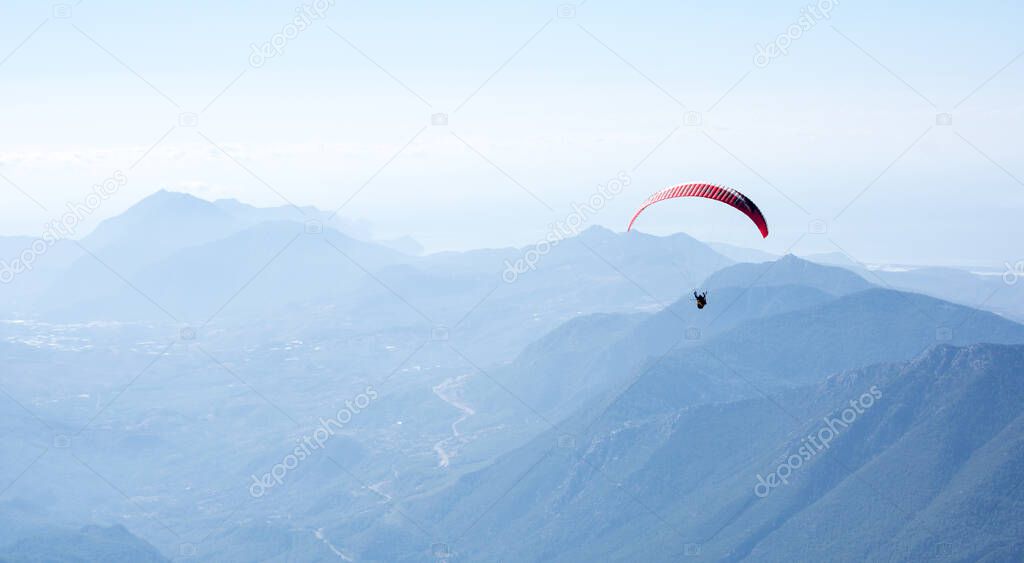Paraglider flying over mountains near Kemer, a seaside resort on the Turkish Riviera in Antalya Province, Turkey