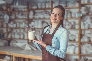 Seramik vazo içinde çanak çömlek ile gülümseyen genç kız