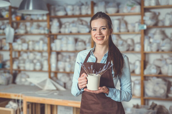 Smiling young girl with a ceramic vase