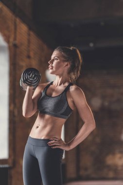 Çatı katında dumbbells ile atletik genç kız