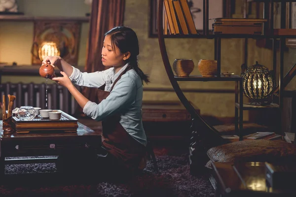 Junge Asiatische Frau Gießt Tee Drinnen — Stockfoto