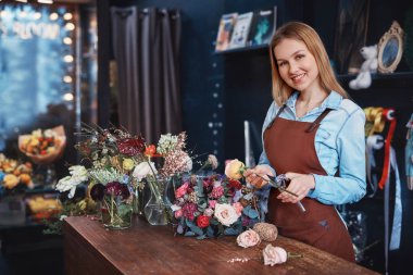 Kasanın arkasındaki çiçekli gülümseyen genç kız