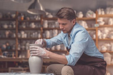 Potter's tekerlek çanak çömlek içinde olan genç adam